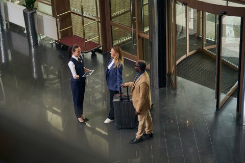 hotel manager greets guests in a hotel