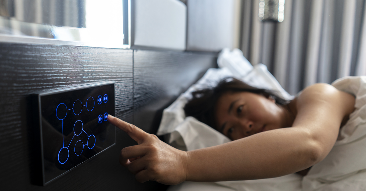 A woman wakes up in a tech-forward hotel room